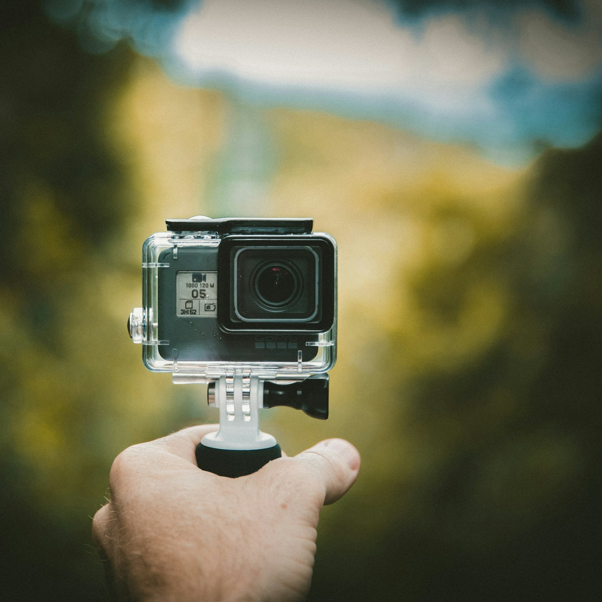 Rider holding an action camera for a handlebar mount