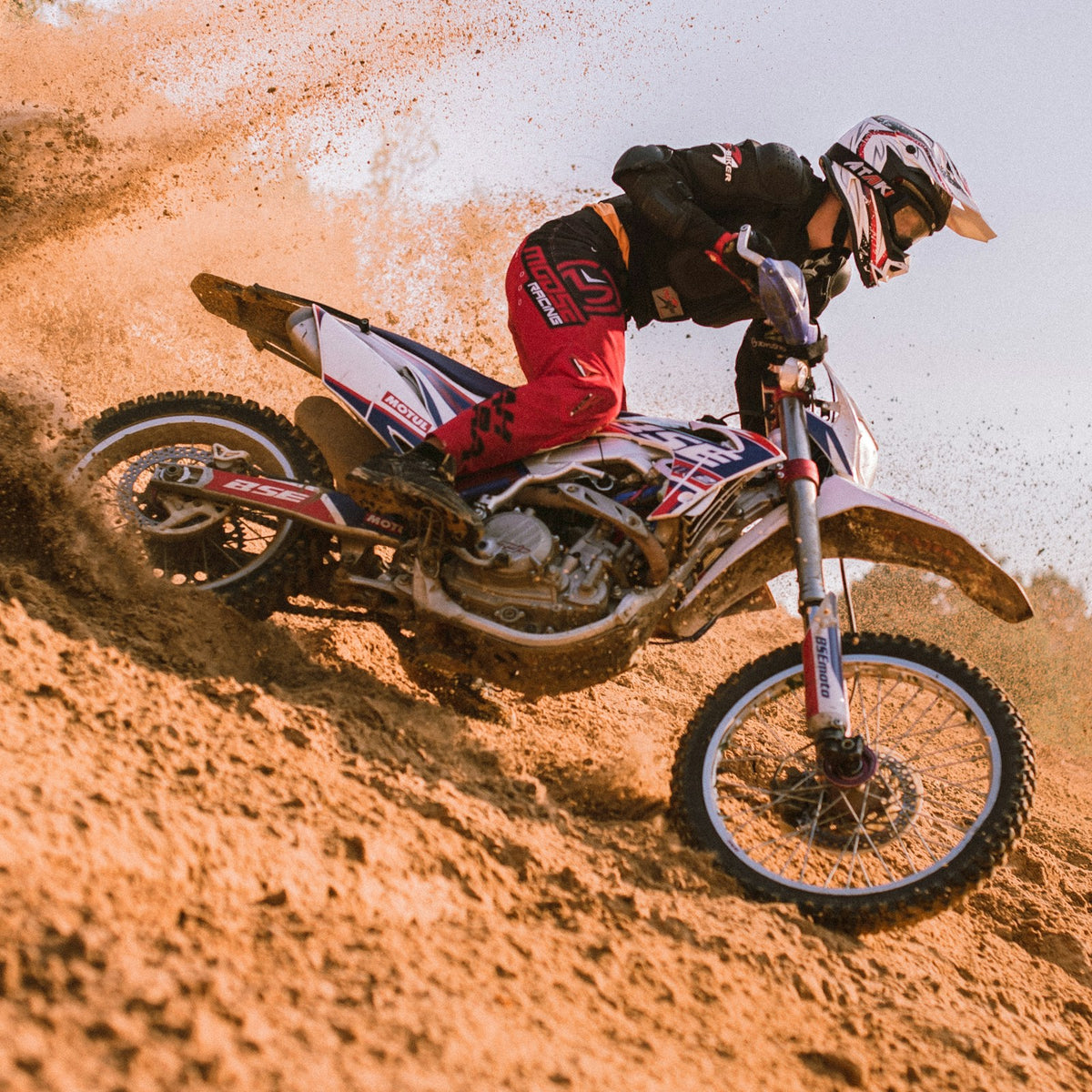 Motocross rider in a red and black off-road suit
