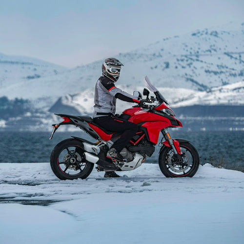Rider in a winter motorcycle jacket in a snowy landscape