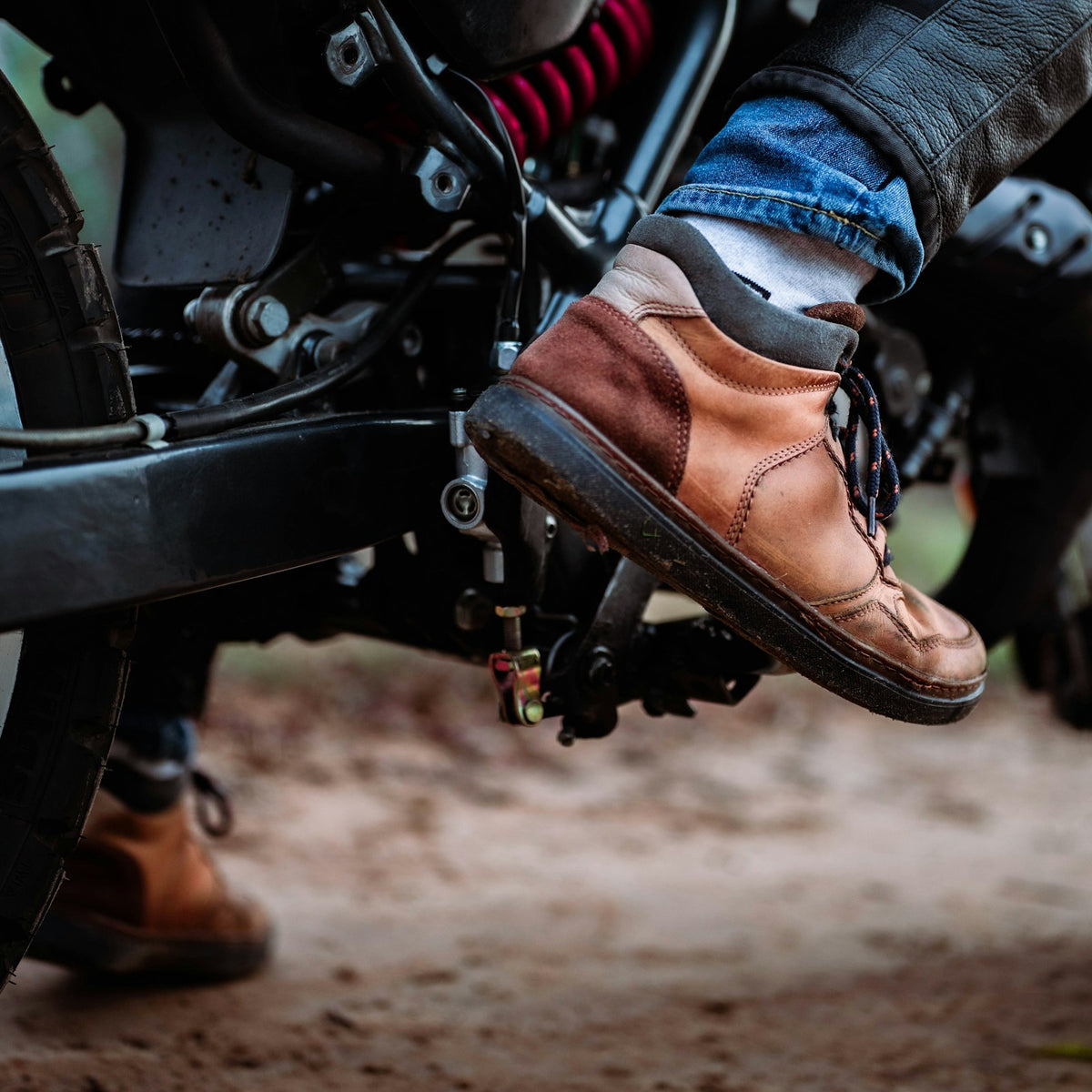 Rider wearing brown casual riding boots on a motorcycle