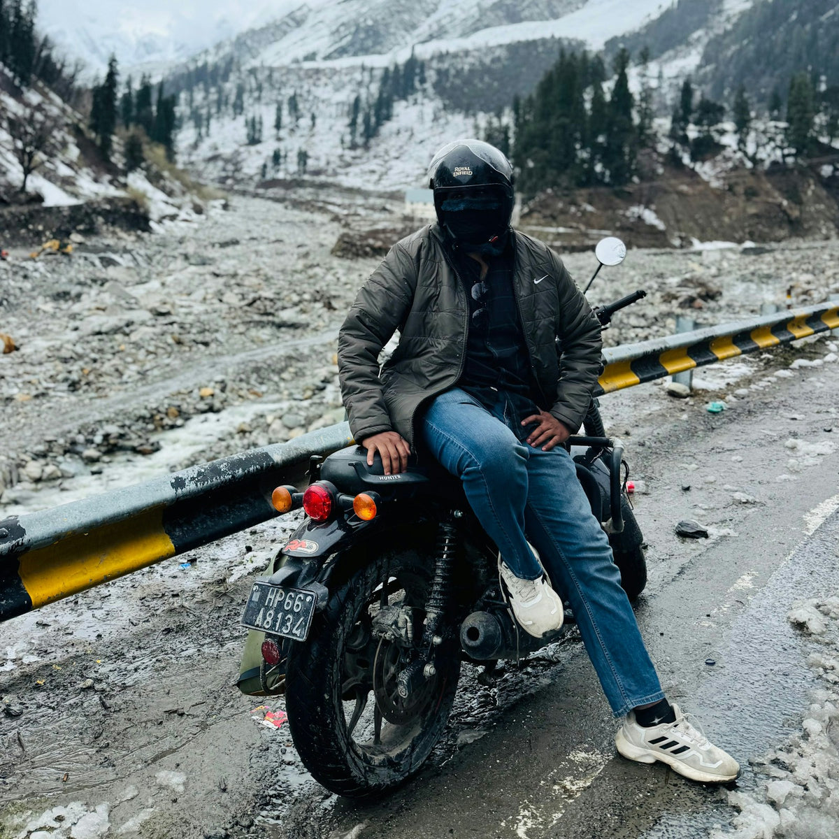 Motorcyclist in a thermal jacket with snowy mountains behind