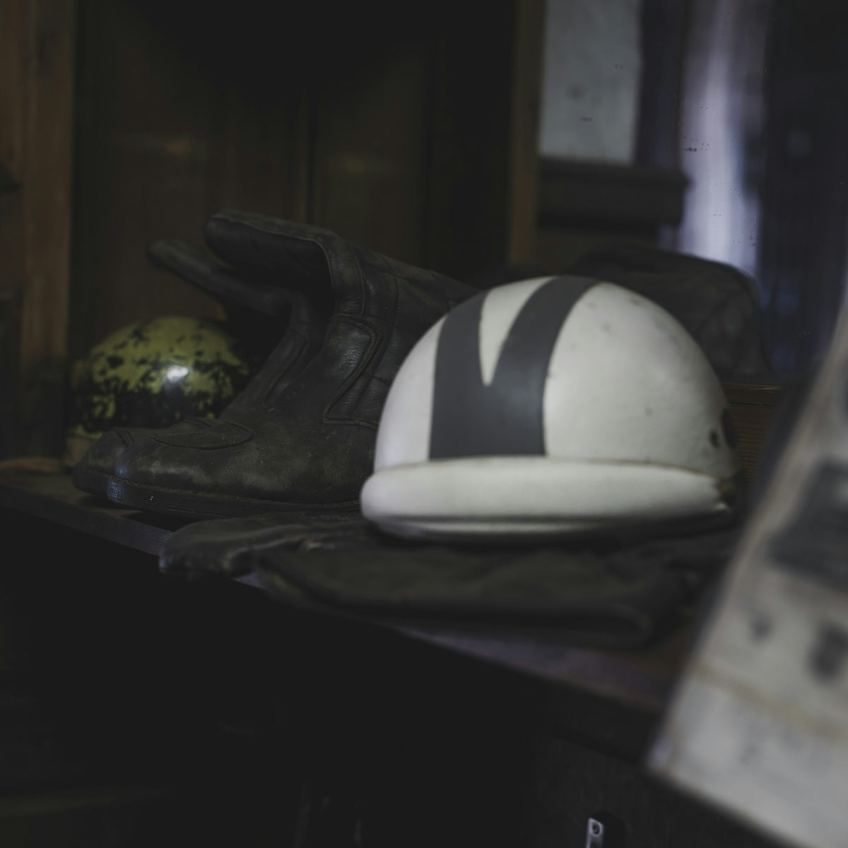 Dark cruiser riding boots and helmet on a shelf